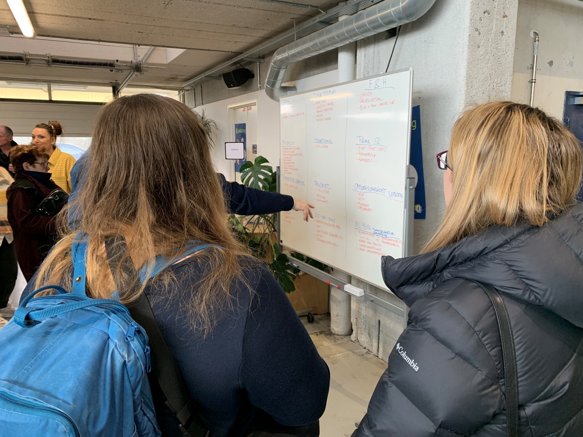 En gruppe betragter tavlen, hvor man kan se, hvilke virksomheder og job, der er repræsenteret